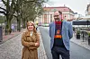 Niina Ratilainen ja Ville Lintunen keskustelevat Turun keskustassa ravintolan edustalla, taustalla katu ja historiallisia rakennuksia.